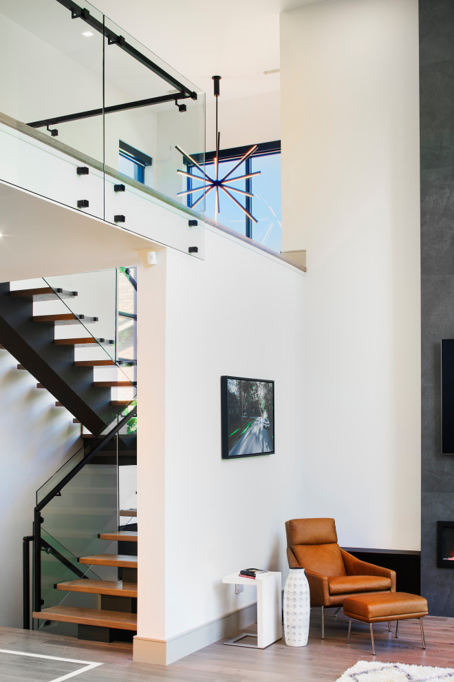 Источник вдохновения для домашнего уюта: большая п-образная лестница в стиле неоклассика (современная классика) с стеклянными перилами без подступенок