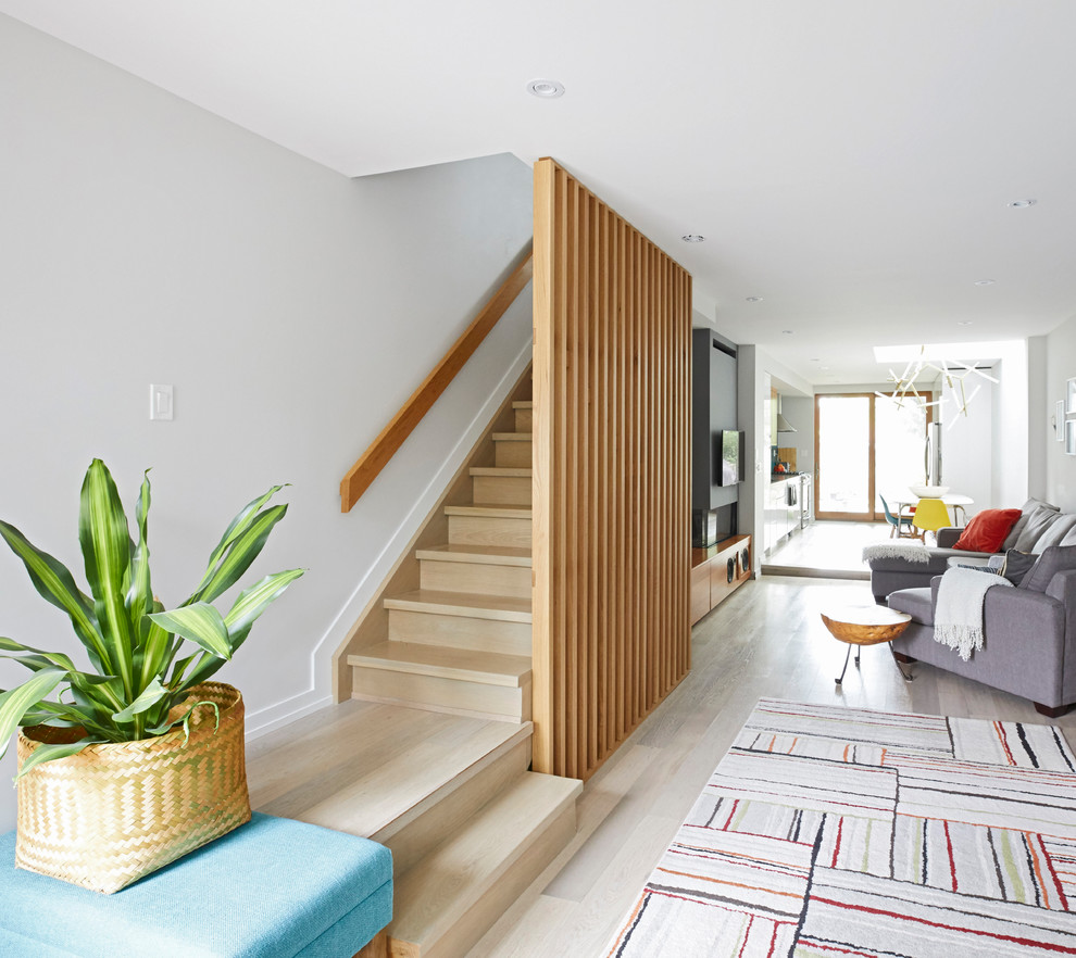 Idée de décoration pour un escalier flottant minimaliste de taille moyenne avec des marches en bois, des contremarches en bois et un garde-corps en bois.