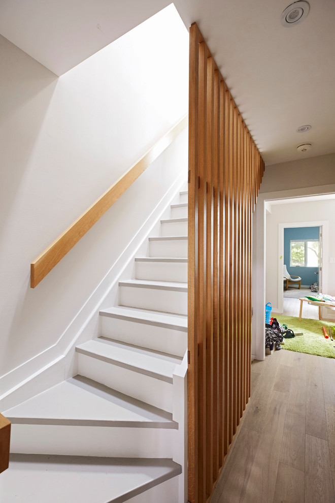 Cette image montre un escalier flottant minimaliste de taille moyenne avec des marches en bois, des contremarches en bois et un garde-corps en bois.