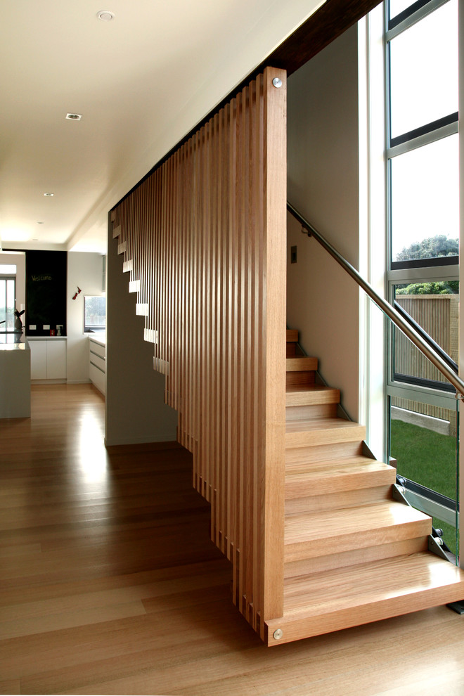Пример оригинального дизайна: деревянная лестница на больцах, среднего размера в стиле модернизм с деревянными ступенями