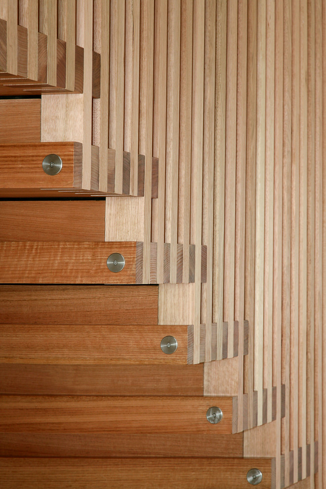 Ejemplo de escalera suspendida minimalista de tamaño medio con escalones de madera y contrahuellas de madera