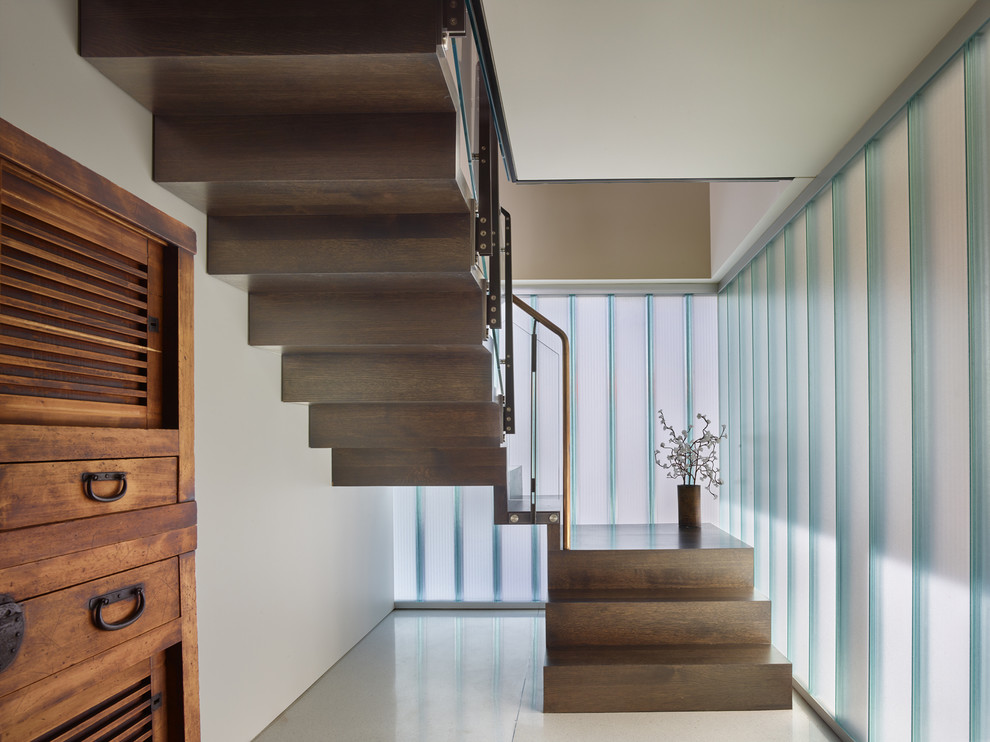 Imagen de escalera suspendida contemporánea pequeña con escalones de madera y contrahuellas de madera