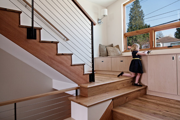 Modelo de escalera en U actual de tamaño medio con escalones de madera, contrahuellas de madera y barandilla de varios materiales