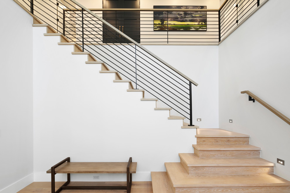 Foto de escalera en L moderna de tamaño medio con escalones de madera, contrahuellas de madera y barandilla de metal