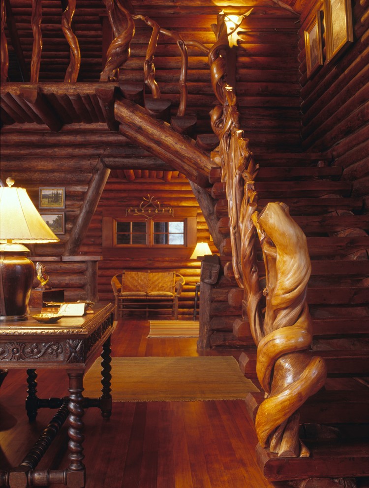 Exempel på en stor rustik l-trappa i trä, med räcke i trä