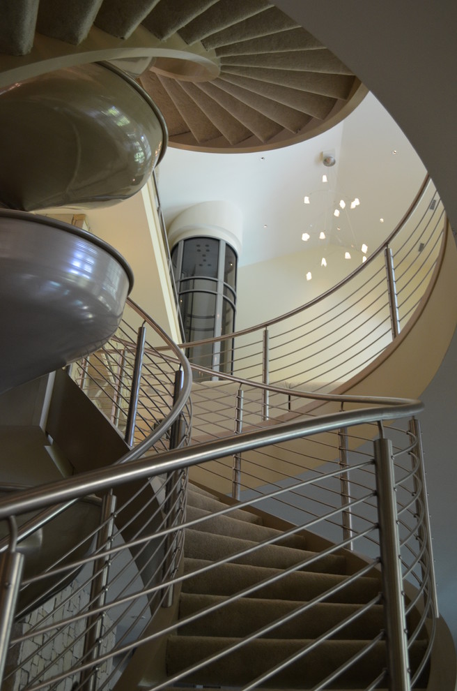 Photo of a large contemporary carpeted spiral staircase in Baltimore with carpeted risers.