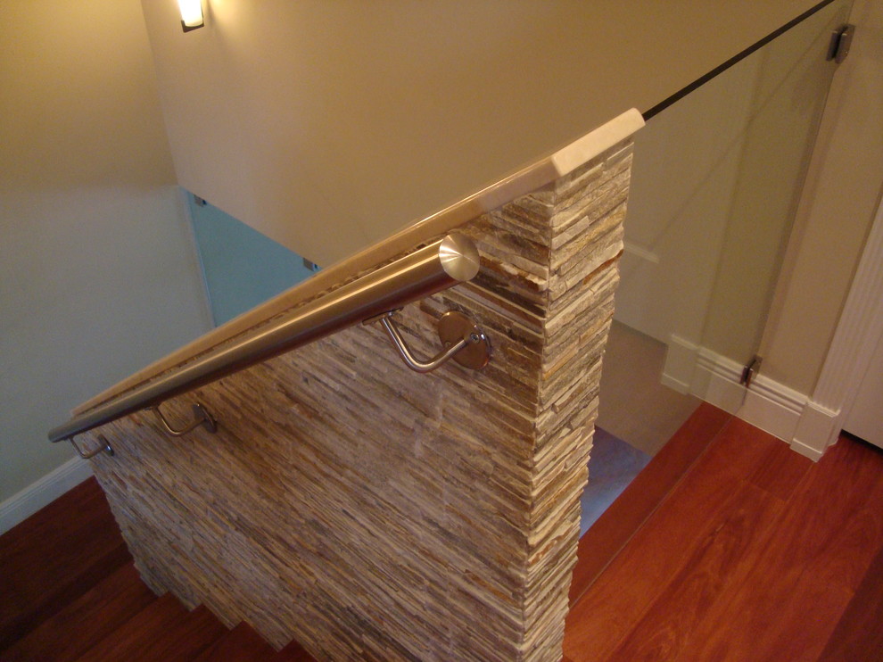 Idée de décoration pour un escalier droit tradition de taille moyenne avec un garde-corps en verre et des marches en bois.