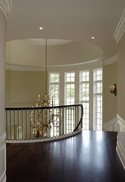 Свежая идея для дизайна: огромная изогнутая лестница в классическом стиле с деревянными ступенями и крашенными деревянными подступенками - отличное фото интерьера