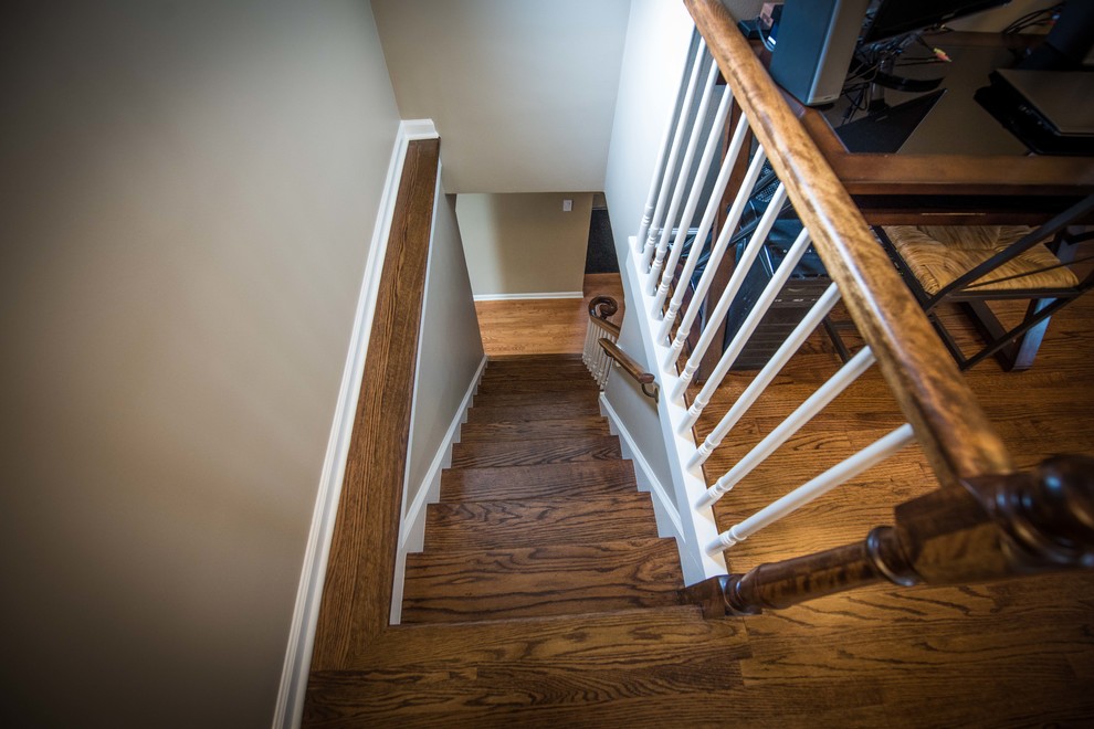 Ejemplo de escalera recta pequeña con escalones de madera, contrahuellas de madera, barandilla de madera y todos los tratamientos de pared