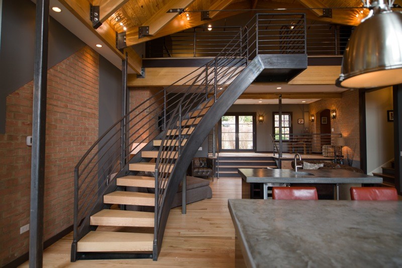 Réalisation d'un grand escalier courbe design avec des marches en bois et des contremarches en bois.