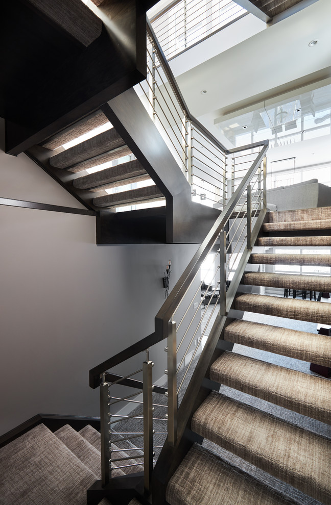 Imagen de escalera suspendida moderna grande con escalones enmoquetados y barandilla de varios materiales