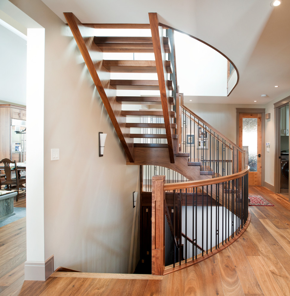 Aménagement d'un grand escalier sans contremarche craftsman en L avec des marches en bois et un garde-corps en matériaux mixtes.