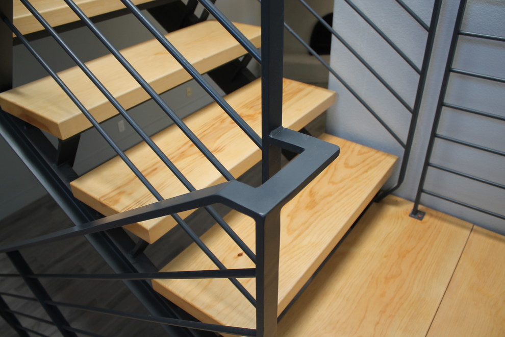На фото: п-образная лестница в стиле модернизм с деревянными ступенями и металлическими перилами без подступенок с
