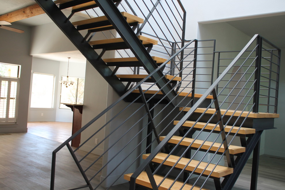 Modelo de escalera en U moderna sin contrahuella con escalones de madera y barandilla de metal