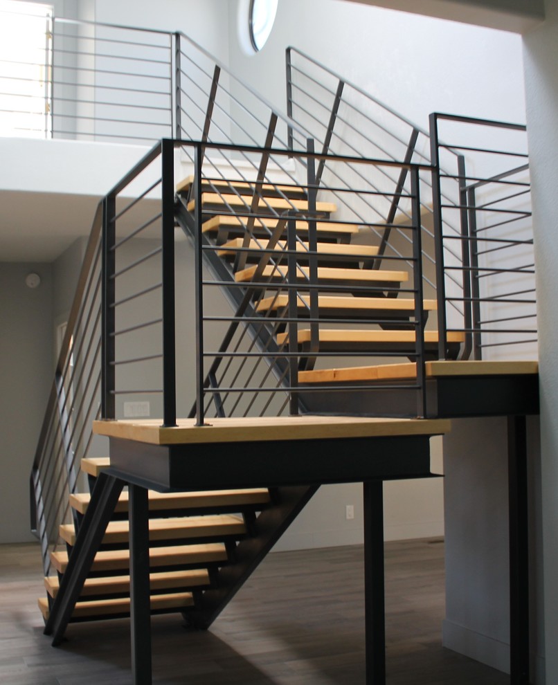 На фото: п-образная лестница в стиле модернизм с деревянными ступенями и металлическими перилами без подступенок с