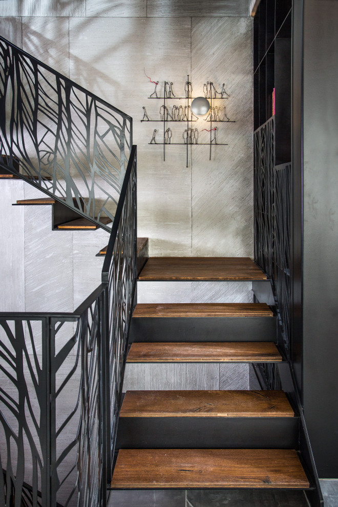На фото: большая п-образная металлическая лестница в стиле лофт с деревянными ступенями и металлическими перилами