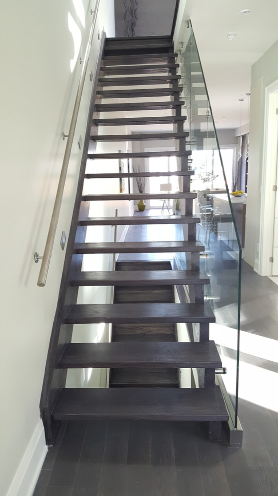 Foto de escalera recta moderna grande sin contrahuella con escalones de madera pintada y barandilla de vidrio