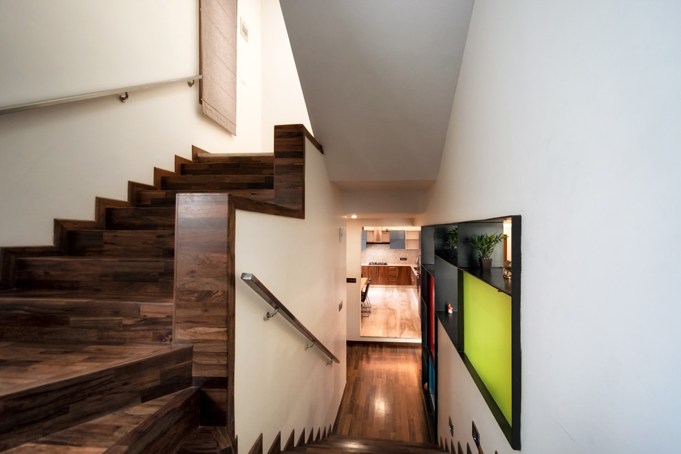 На фото: п-образная деревянная лестница среднего размера в современном стиле с деревянными ступенями и металлическими перилами с