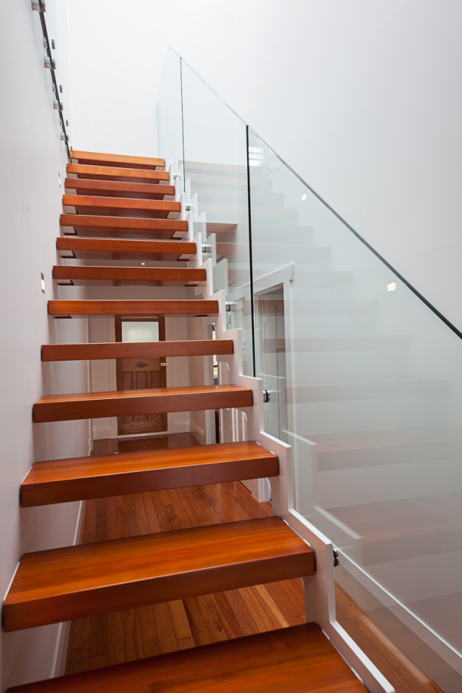 オークランドにある高級な広いコンテンポラリースタイルのおしゃれな階段 (ガラスフェンス) の写真