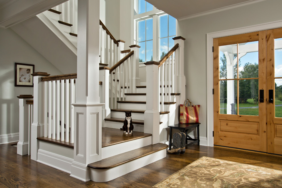 На фото: п-образная лестница в стиле кантри с деревянными ступенями и крашенными деревянными подступенками