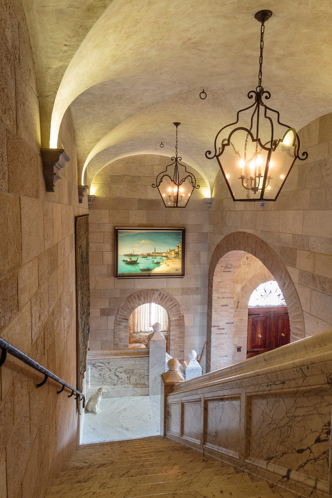 Foto de escalera en L mediterránea con escalones de mármol, contrahuellas de mármol y barandilla de varios materiales