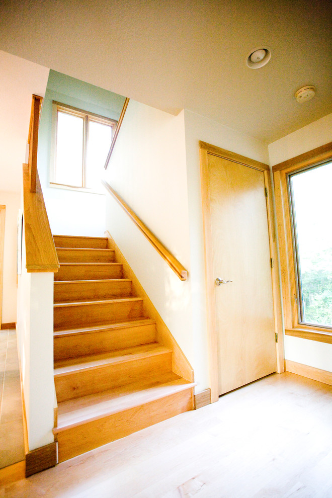 Diseño de escalera en U clásica de tamaño medio con escalones de madera, contrahuellas de madera y barandilla de madera