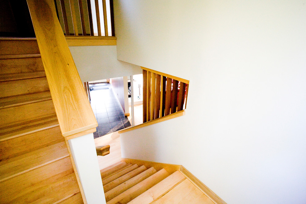 На фото: п-образная деревянная лестница среднего размера в стиле модернизм с деревянными ступенями и деревянными перилами