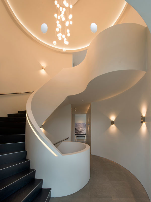 Свежая идея для дизайна: изогнутая деревянная лестница среднего размера в стиле модернизм с деревянными ступенями и металлическими перилами - отличное фото интерьера