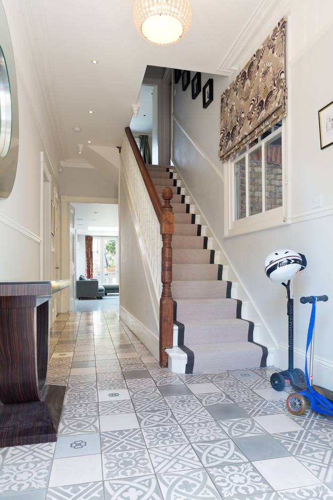Mid-sized trendy painted straight wood railing staircase photo in London with painted risers