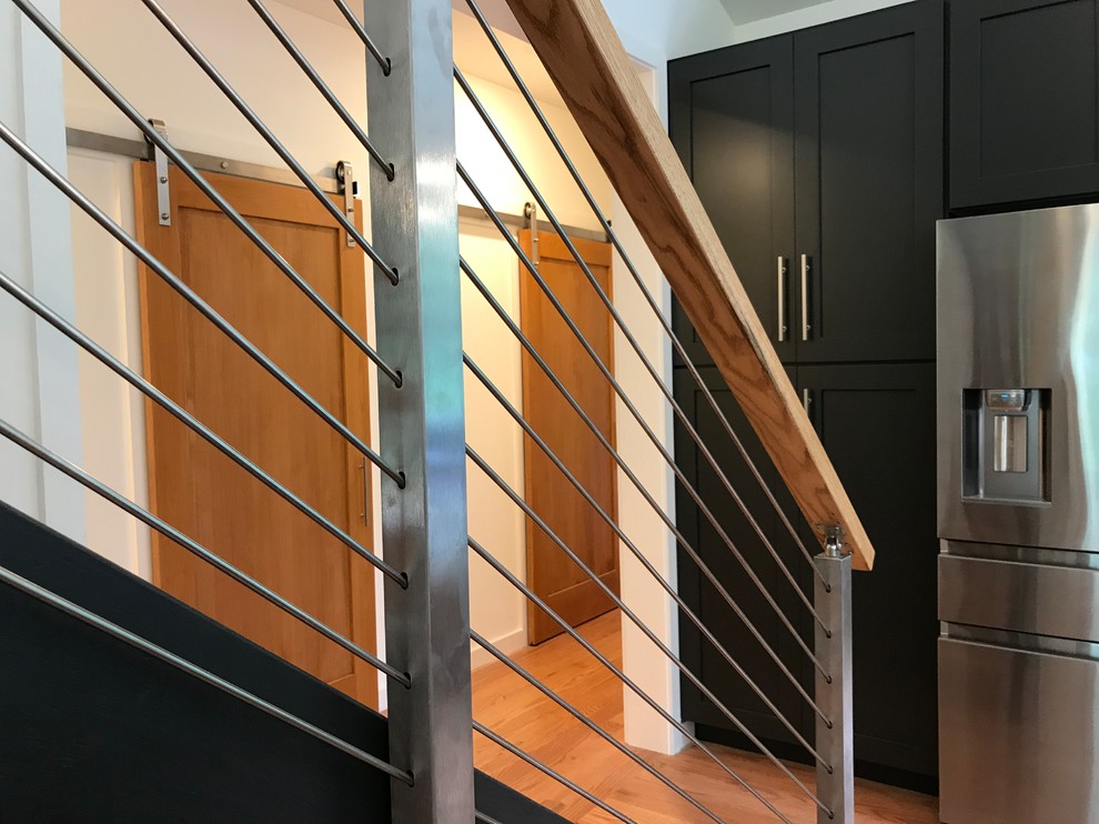 Inspiration pour un escalier sans contremarche droit design de taille moyenne avec des marches en bois et un garde-corps en câble.