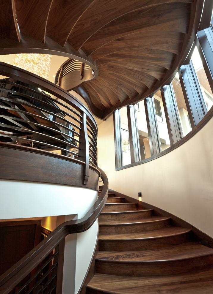 Photo of a large classic wood curved staircase in Salt Lake City with wood risers.