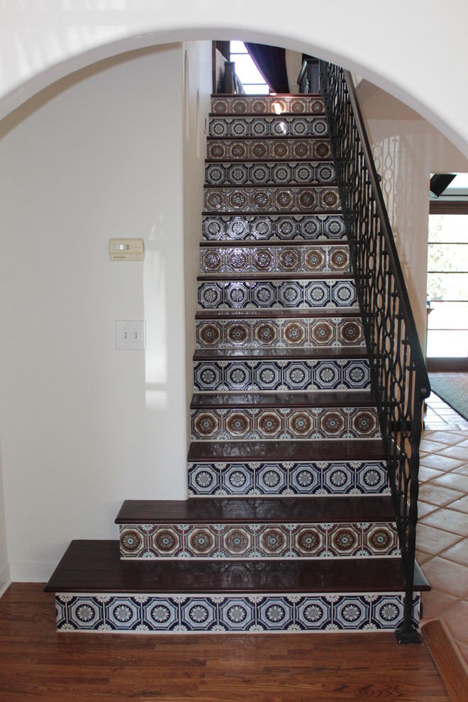 Diseño de escalera recta mediterránea de tamaño medio con escalones de madera y contrahuellas con baldosas y/o azulejos