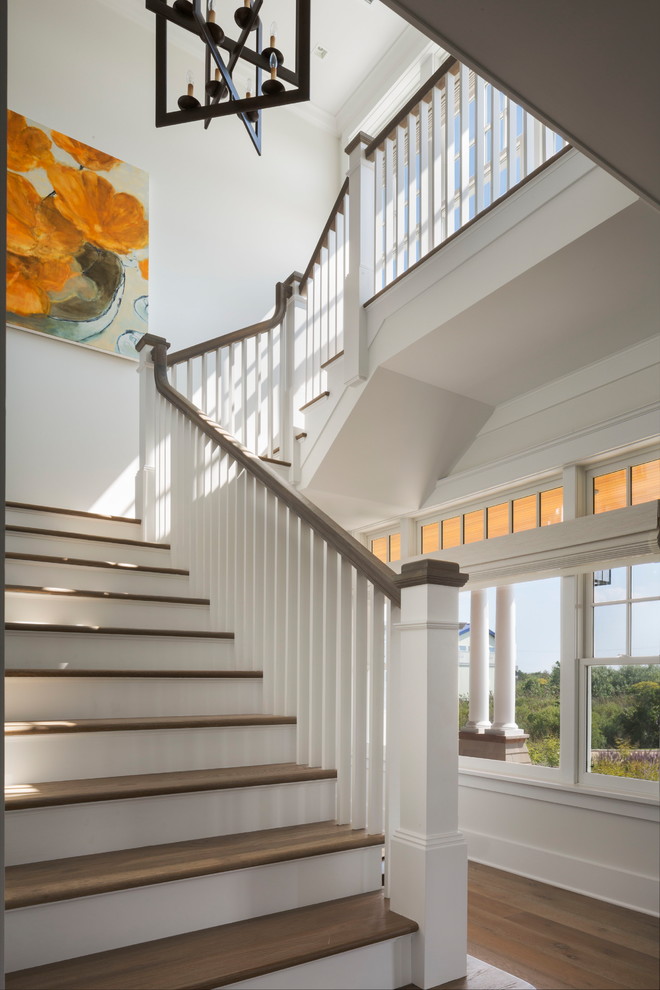 This is an example of a medium sized coastal wood u-shaped wood railing staircase in New York with painted wood risers.