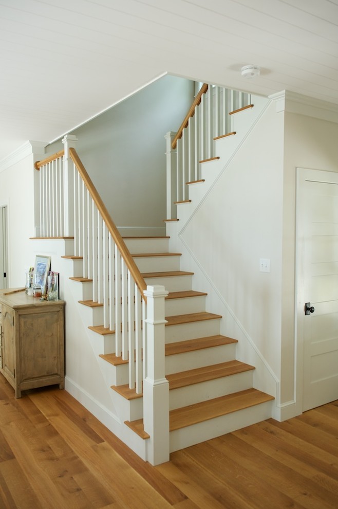 Imagen de escalera en U tradicional de tamaño medio con escalones de madera y contrahuellas de madera pintada