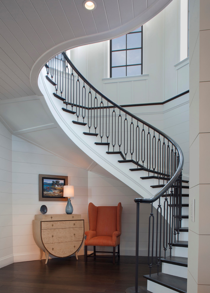 Idée de décoration pour un grand escalier peint marin avec des marches en bois et éclairage.