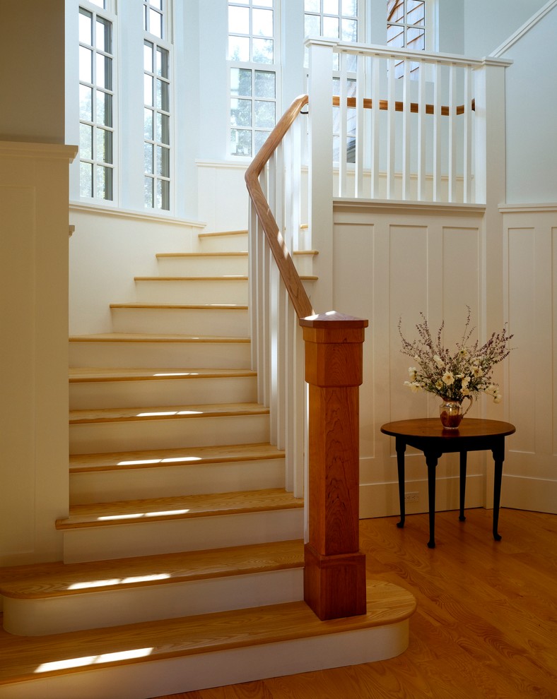 Пример оригинального дизайна: изогнутая деревянная лестница среднего размера в стиле неоклассика (современная классика) с деревянными ступенями