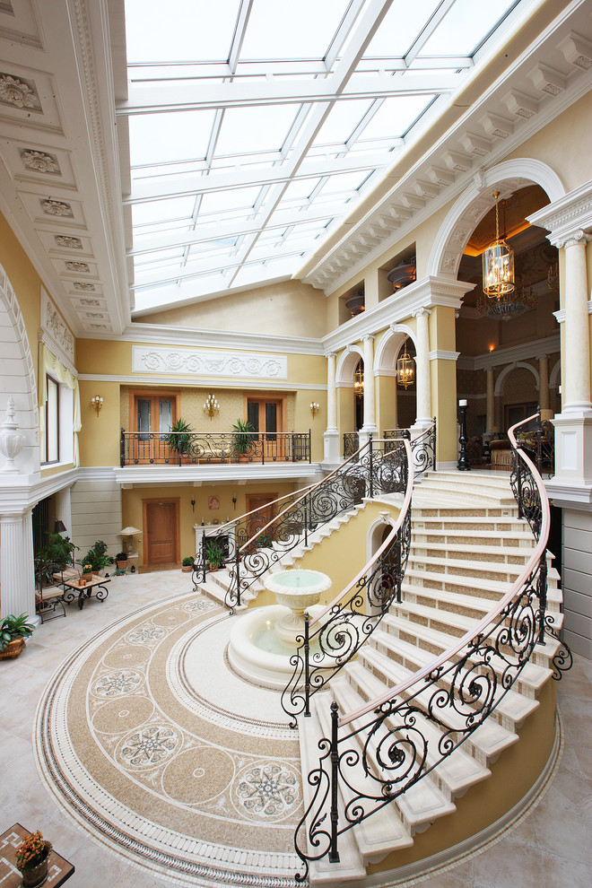 Свежая идея для дизайна: огромная изогнутая лестница в классическом стиле - отличное фото интерьера