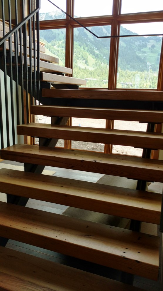 Inspiration för rustika l-trappor i trä, med öppna sättsteg och räcke i metall