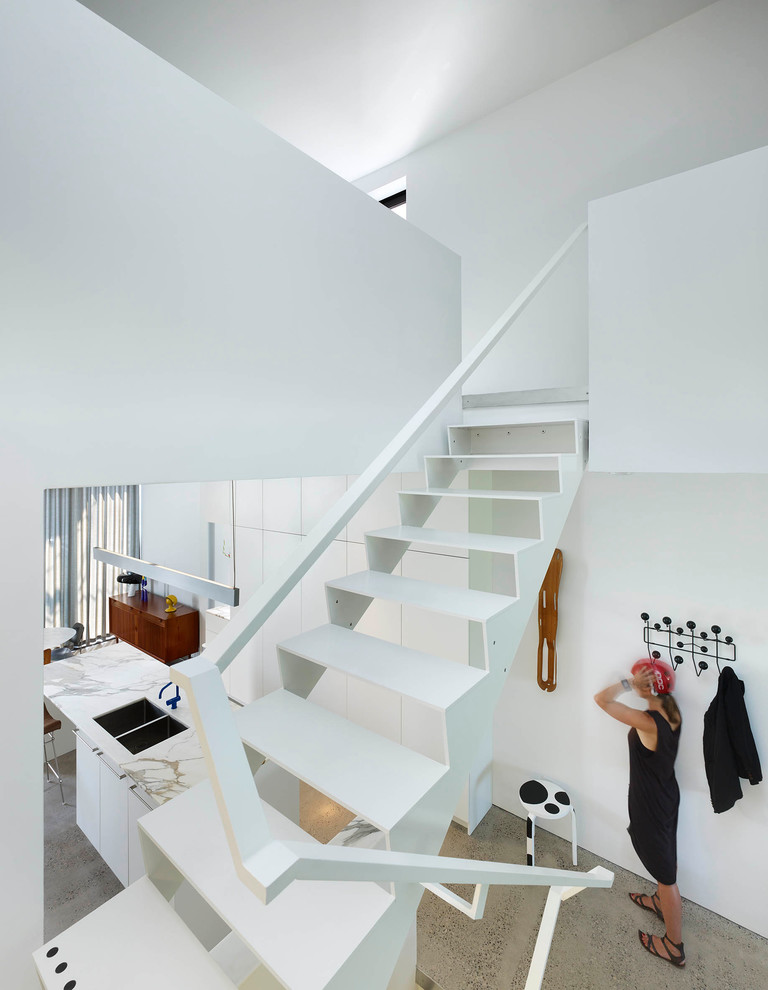 This is an example of a small modern metal u-shaped staircase in Toronto with open risers.