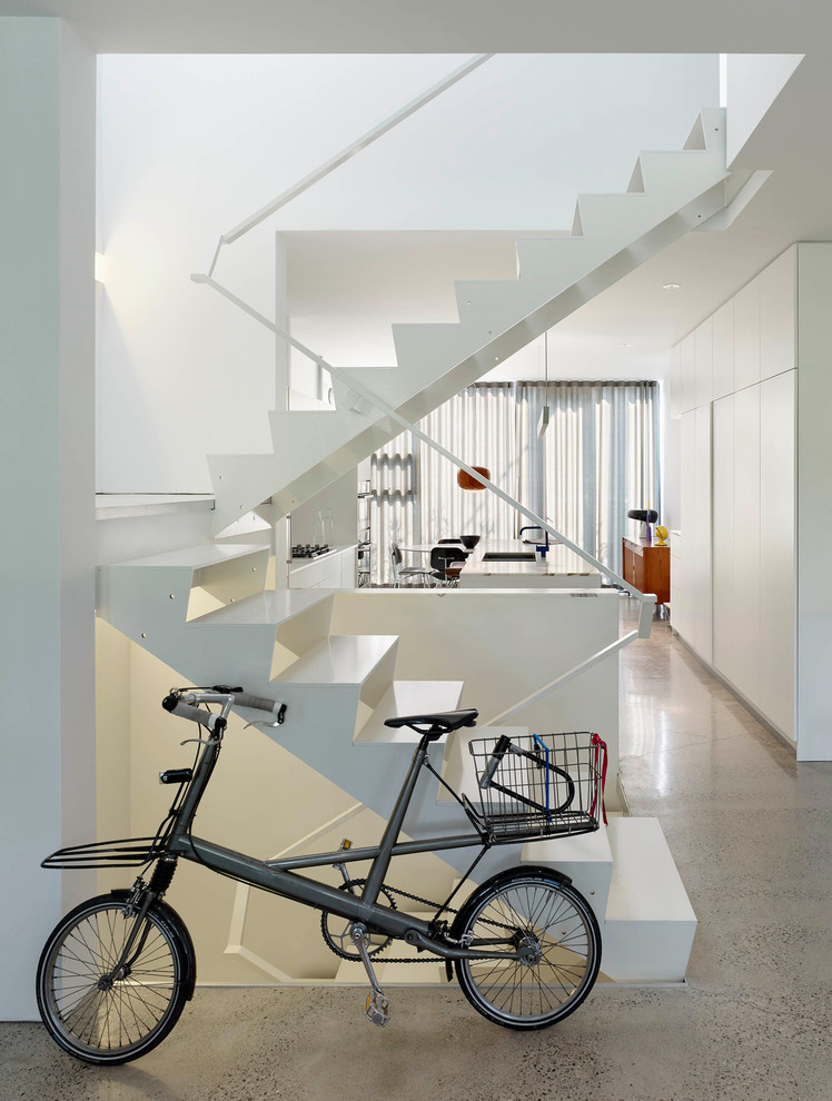Cette photo montre un petit escalier sans contremarche moderne en U avec des marches en métal et éclairage.