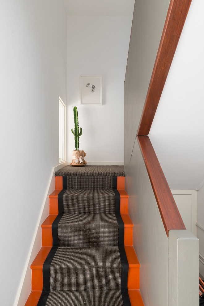 Moderne Treppe in L-Form mit gebeizten Holz-Treppenstufen und gebeizten Holz-Setzstufen in London