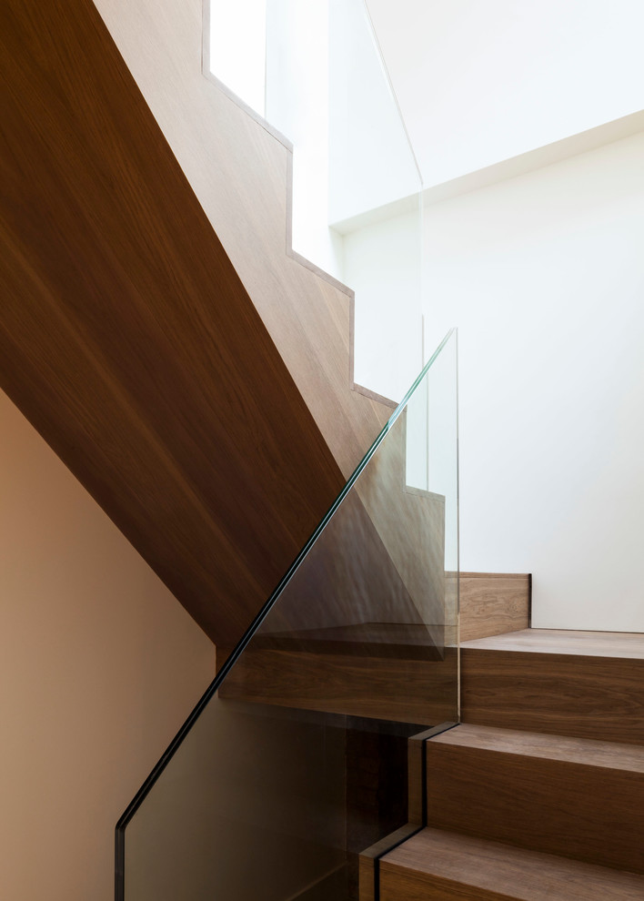 This is an example of a medium sized contemporary wood u-shaped staircase in London with wood risers.