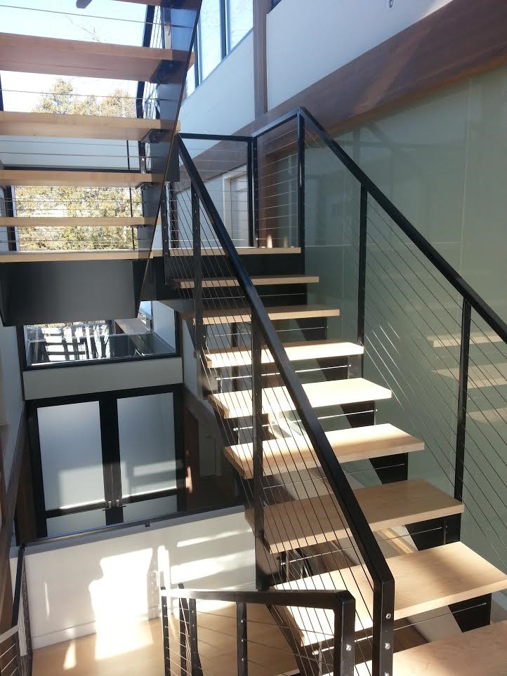 Imagen de escalera suspendida actual grande sin contrahuella con escalones de madera