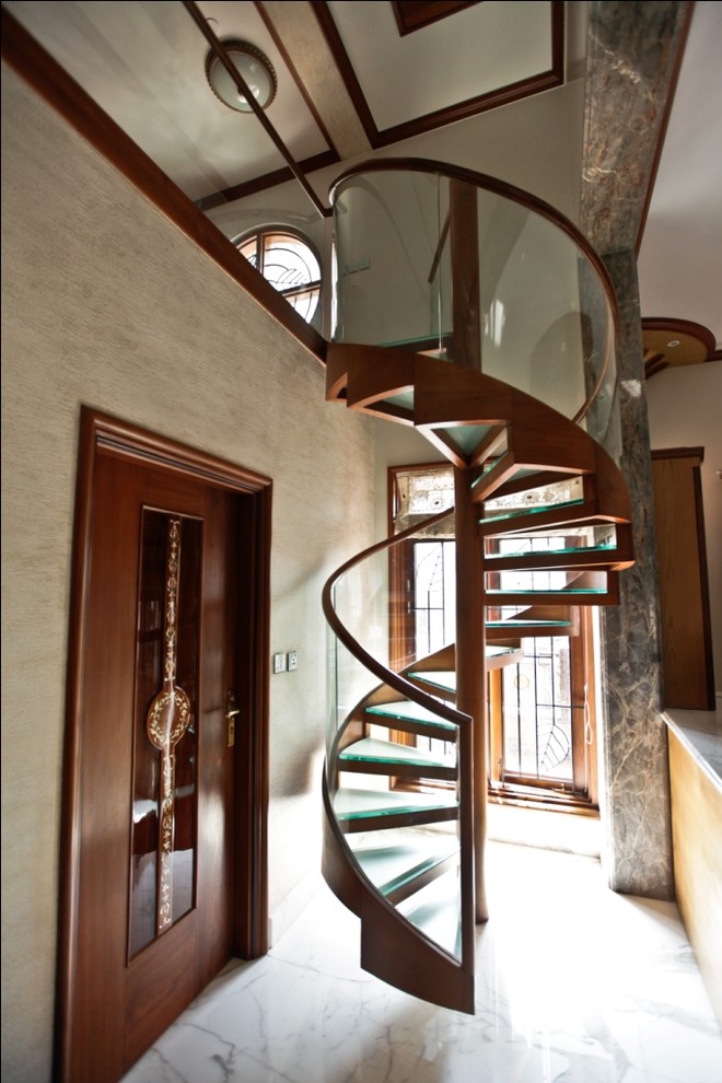 Cette image montre un petit escalier hélicoïdal design avec des marches en verre.