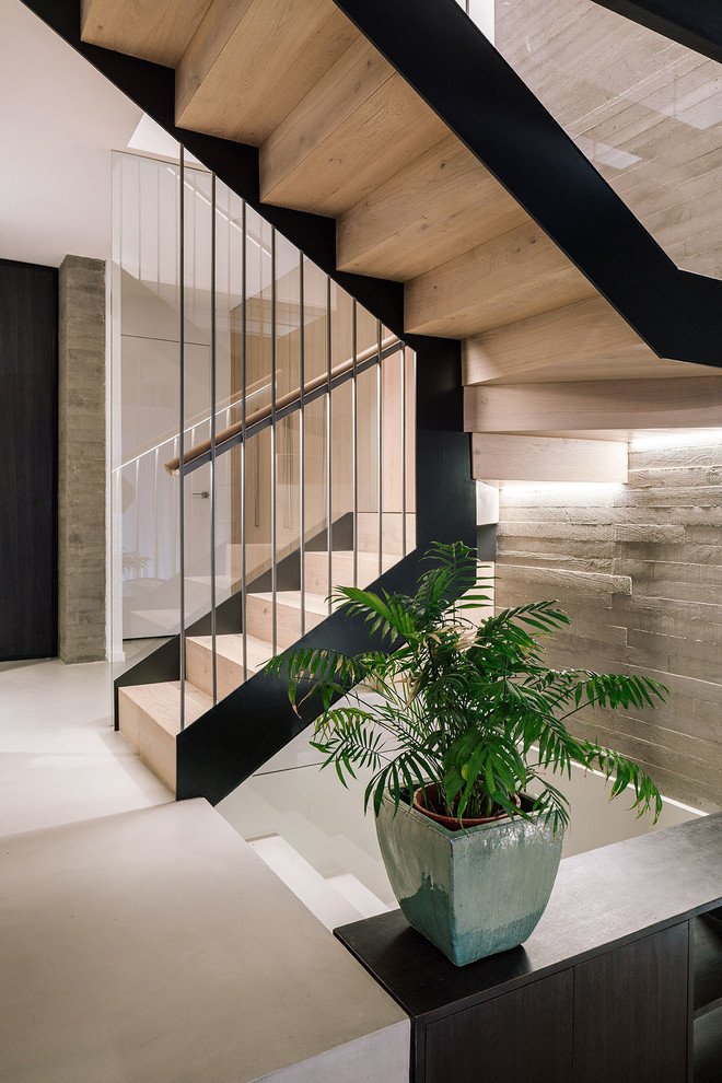 Ejemplo de escalera en U contemporánea de tamaño medio con escalones de madera, contrahuellas de madera y barandilla de madera