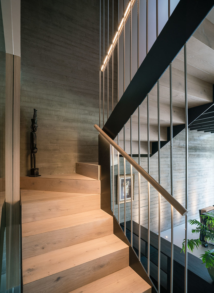 Imagen de escalera en U contemporánea de tamaño medio con escalones de madera, contrahuellas de madera y barandilla de madera