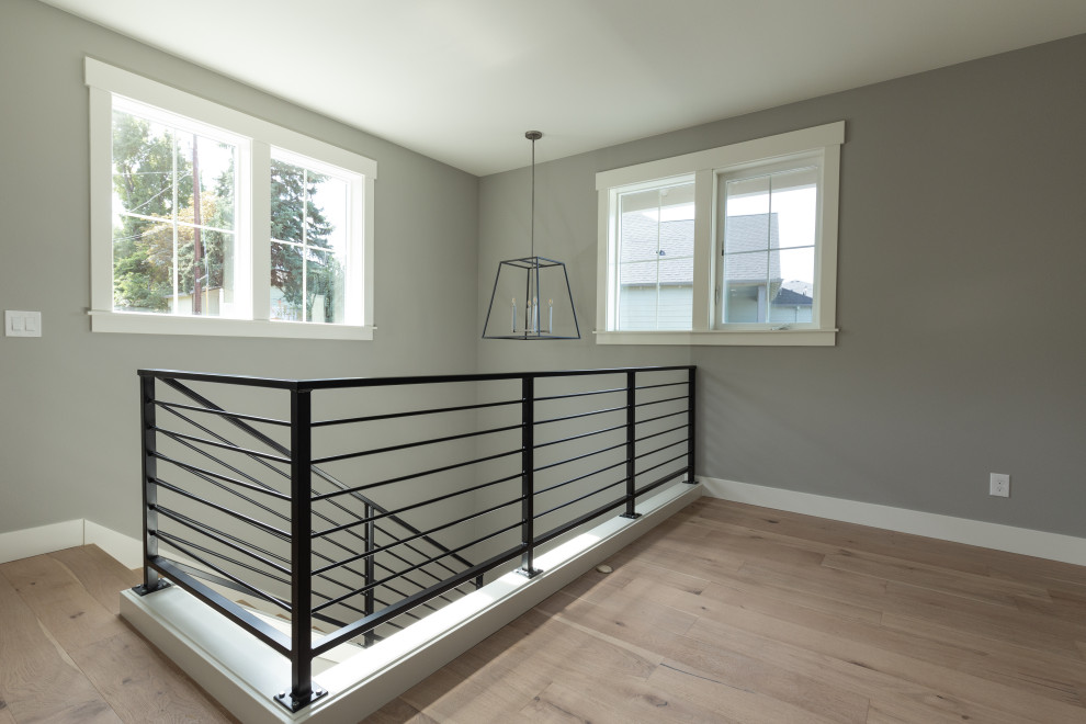 Large farmhouse wood l-shaped metal railing staircase in Portland with wood risers.