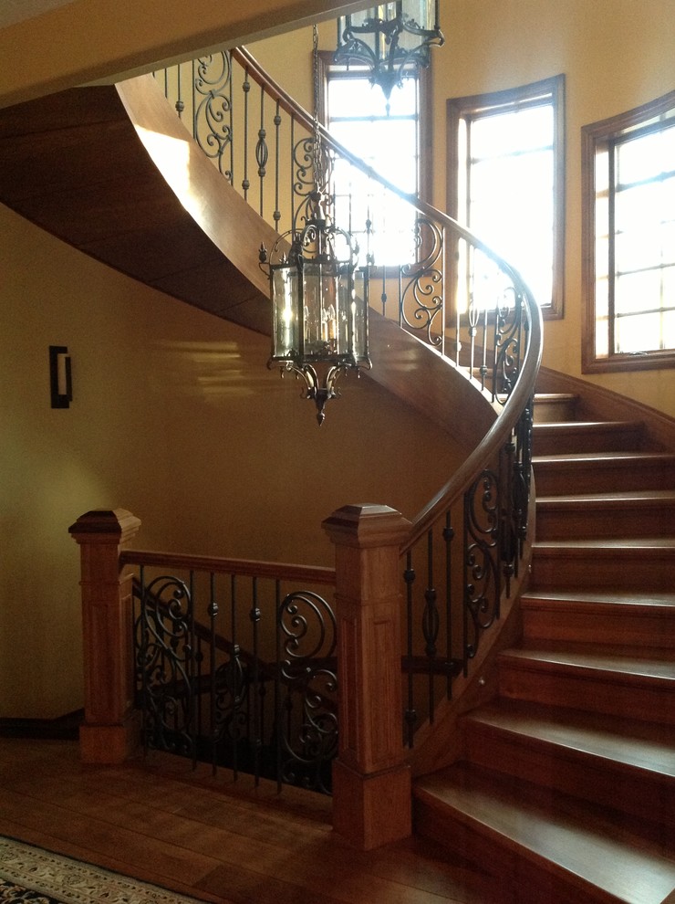 Réalisation d'un grand escalier sans contremarche courbe tradition avec des marches en bois.