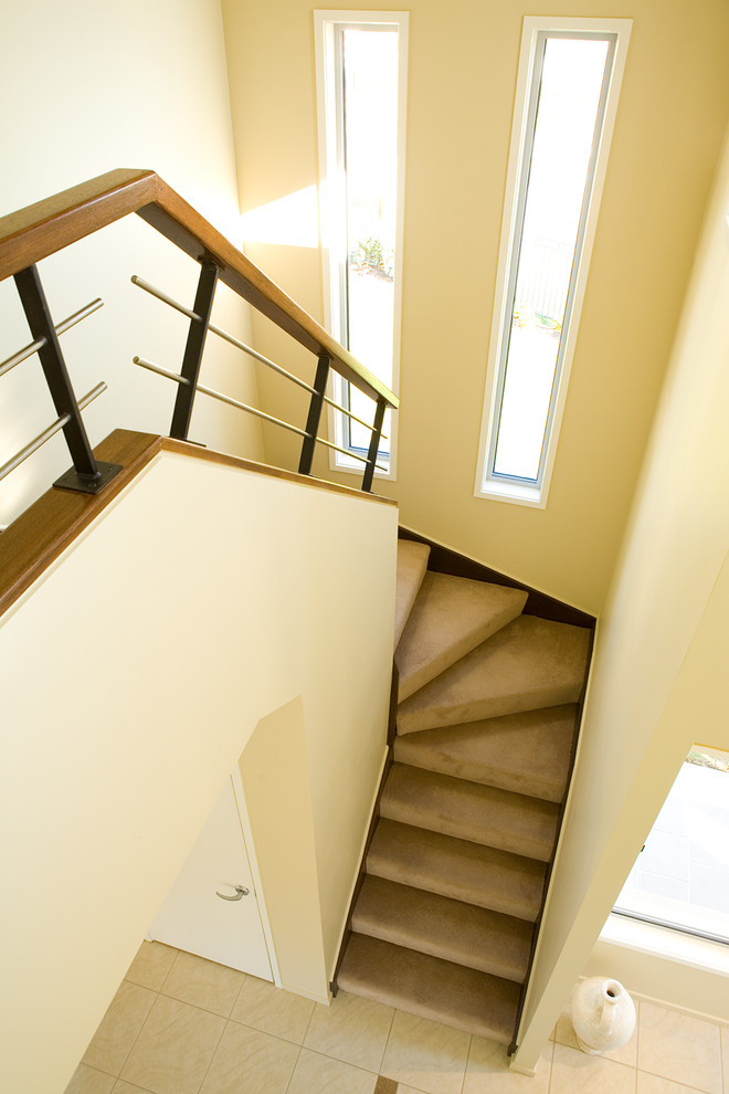 На фото: маленькая п-образная лестница с ступенями с ковровым покрытием и ковровыми подступенками для на участке и в саду с