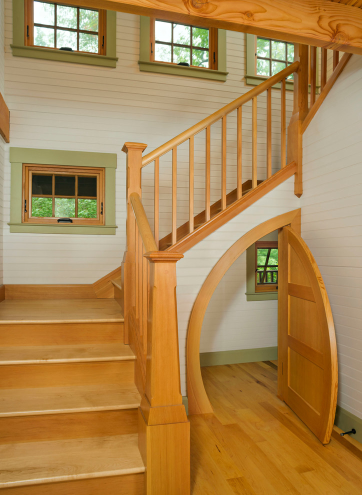 Small rustic wood u-shaped staircase in Boston with wood risers and under stair storage.